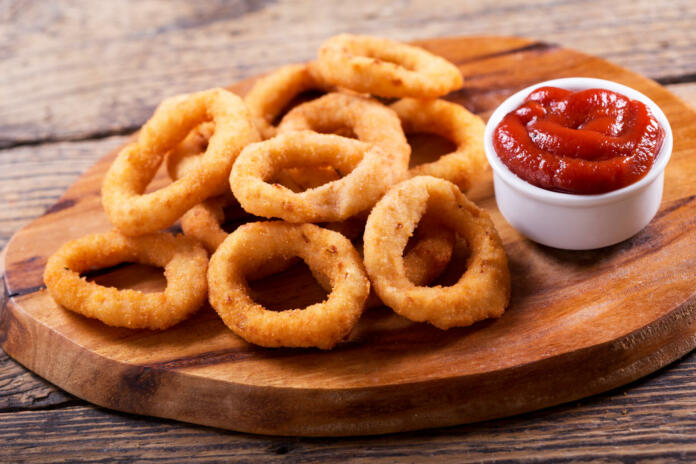 onion rings with ketchup on wooden board