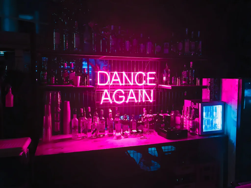 neonski napis "dance again" v baru