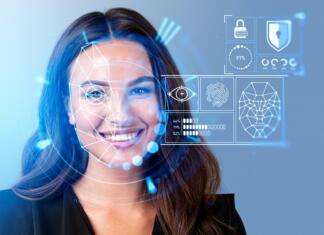 Startup razvil oblačila, ki pretentajo umetno inteligenco Smiling businesswoman in formal wear watching at digital interface with facial recognition by digital interface with line connection hologram. Concept of modern technology of artificial intelligence