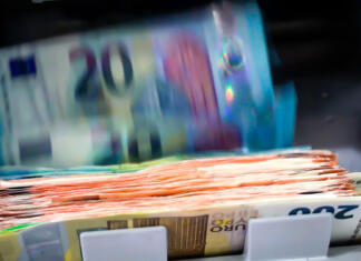 Koliko znaša javni dolg Slovenije? The Euro Currency Banknotes In A Currency Counting Machine.