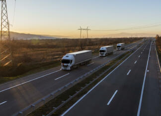 Švedska gradi prvo cesto na svetu, ki bo omogočala polnjenje električnih vozil med vožnjo Transportation trucks passing by on a country highway under a beautiful sky. Business Transportation And Trucking Industry.