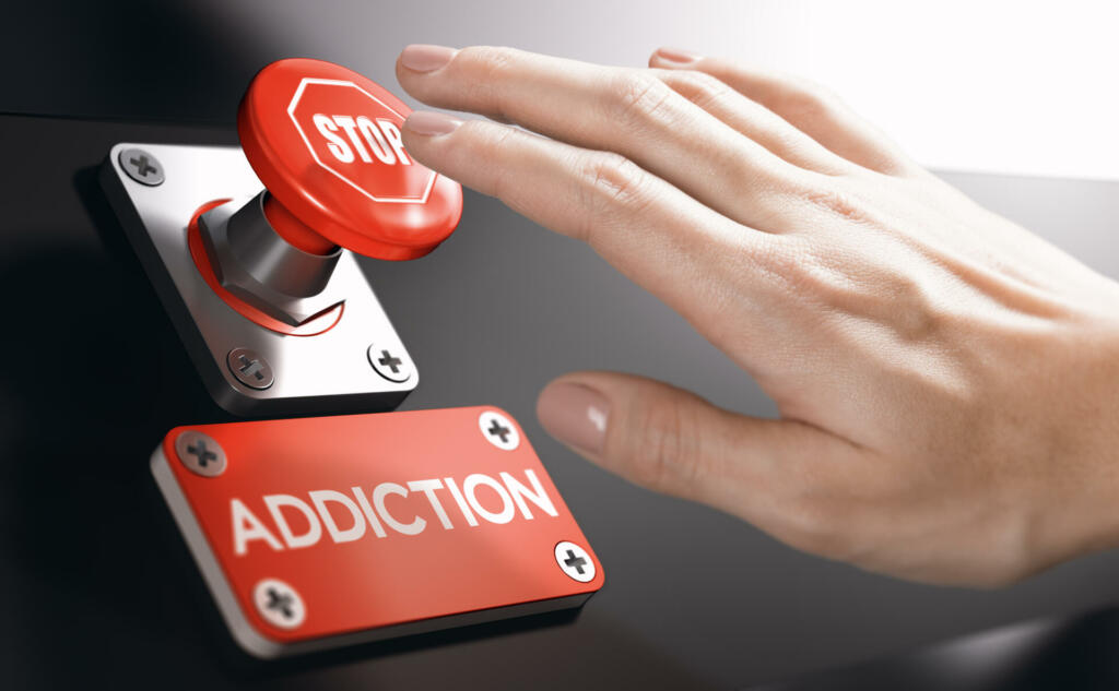 Woman pressing a panic button with stop sign to overcome addiction or dependence problems. Psychology concept.