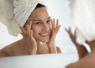 Ali kreme s kolagenom dejansko delujejo? Ženska, ki si maže obraz.