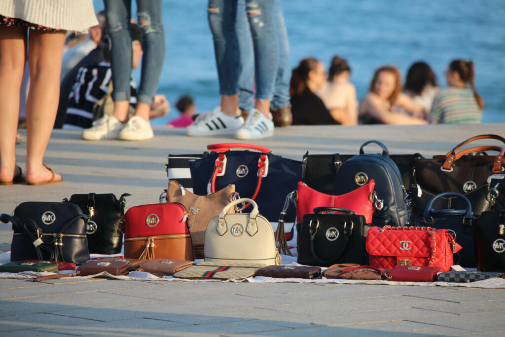 Barcelona, Spain - October 29, 2016: Copies of popular brands of women bags sold on the Barceloneta beach