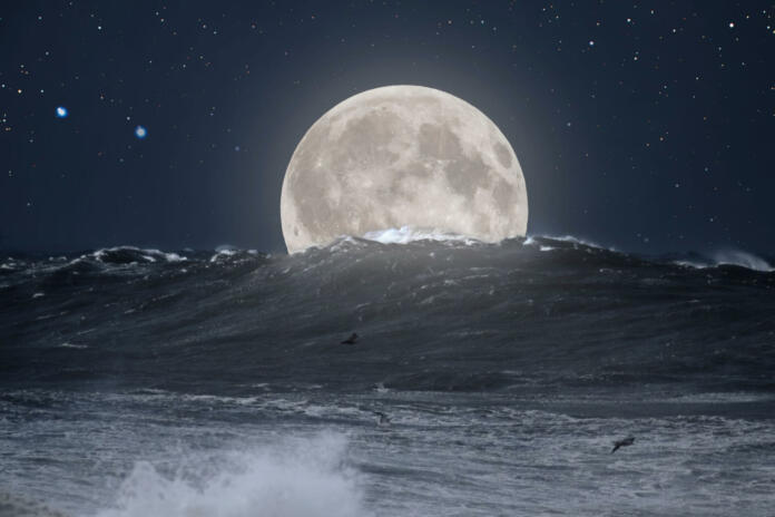 Big stormy Atlantic sea wave in a clear full moon night