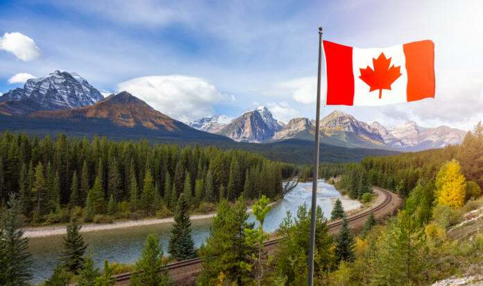 Canadian National Flag composite with Rocky Mountain Landscape in background. Fall Season Sunny Sky. Lake Louise, Banff National Park, Alberta, Canada.