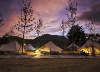 Najboljši glampingi v Sloveniji Canvas glamping bell tents in a green field with walkway at mountain view in beautiful sky with cloud before sunrise.