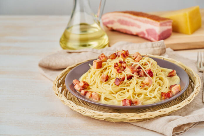 Carbonara pasta. Spaghetti with pancetta, egg, parmesan cheese and cream sauce. Side view, copy space. Traditional italian cuisine.
