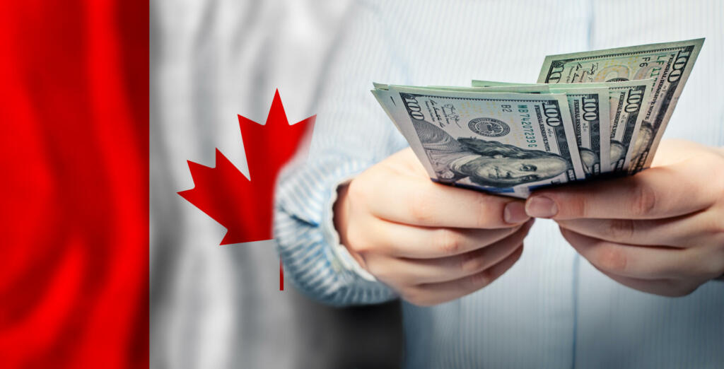 Currency exchange, finanse, banking and saving money in Canada. US dollars cash on Canadian flag background