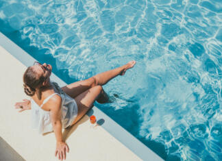 Na kaj moraš biti pozoren pri izbiri sončne kreme? Fashionable woman sitting by the pool on the empty deck of a cruise liner. Closeup, outdoor, view from above. Vacation and travel concept