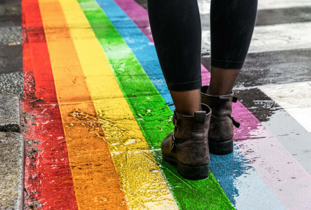 Female legs walking on rainbow crosswalk on Gay pride.