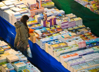 Slovenija šele tretja v zgodovini Frankfurtskega knjižnega sejma s takim dosežkom Llisbon, Portugal - December 5, 2013: A woman looks at a huge stall selling books within the Oriente Railway Station in Lisbon.