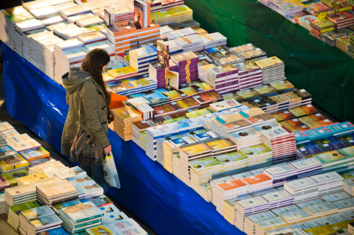 Llisbon, Portugal - December 5, 2013: A woman looks at a huge stall selling books within the Oriente Railway Station in Lisbon.