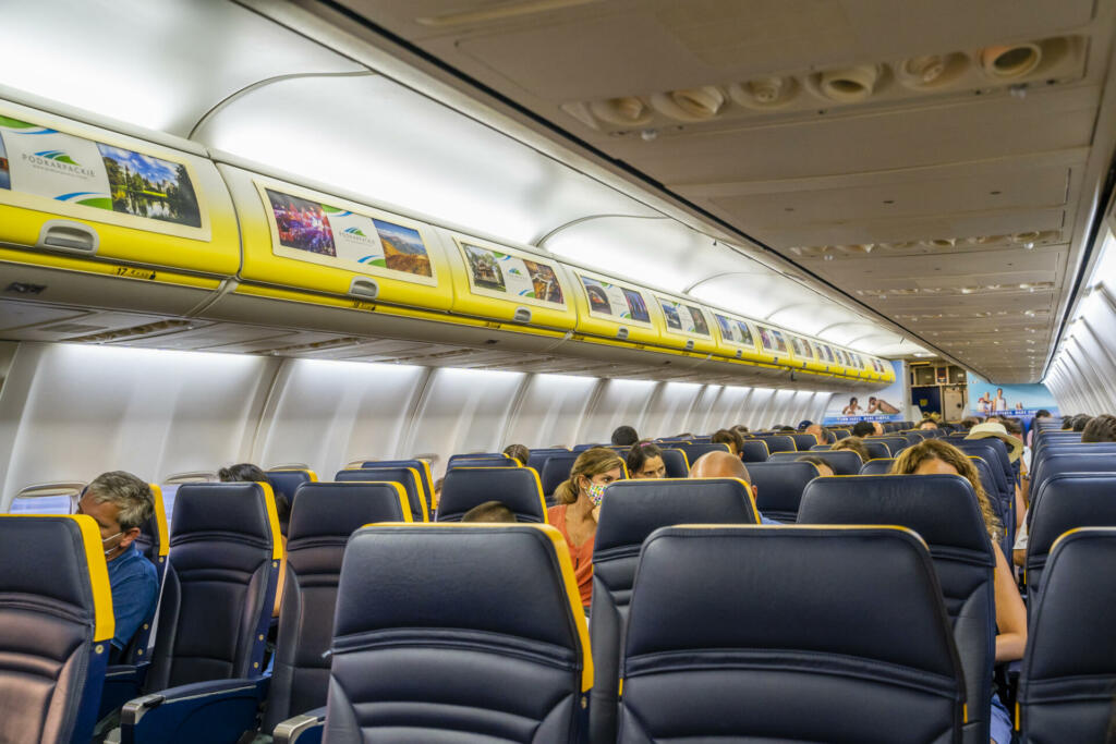 Malaga / Spain - August 15th, 2020: Half empty airplane, passengers with face masks, ryanair