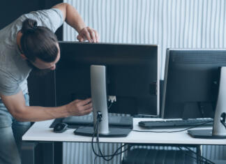 Vodič po nakupu monitorja (del 3): vrste priklopov Network engineer professional career. Man connecting monitor to PC at office workplace. Copy space.