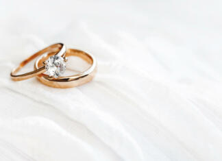 Če se Slovenec ali Slovenka poročita z državljanom druge države, je ta najpogosteje iz … Pair of golden wedding rings on white textile background with copy space. Engagement ring with diamond on fabric backdrop. Symbol of love and marriage.