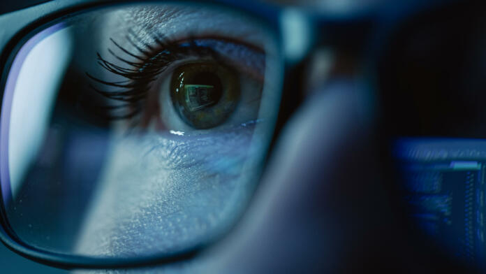 Super Close-up on Female Eye, Software Engineer Working on Computer, Programming Reflecting in Glasses. Developer Working on Innovative e-Commerce Application using Machine Learning, AI, Big Data