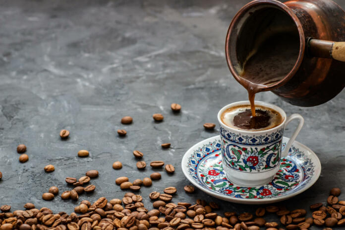 Turkish coffee concept, cup of coffee with coffee beans on dark stone background