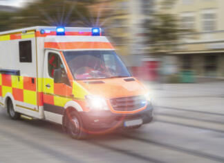 Kaj se zgodi, ko pokličeš 112? Vodič po klicanju številke 112 An emergency vehicle drives through the city with blue lights and high speed