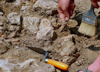 Arheologi odkrili velikanske artefakte na redkem najdišču iz ledene dobe Archeological tools, Archeologist working on site, hand and tool.