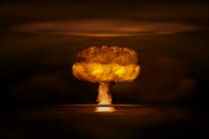 Atomic bomb realistic explosion, orange color with smoke on black background