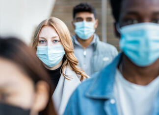 Kako se izogniti naslednji smrtonosni pandemiji, ki se zdi neizogibna? Authentic shot of multiracial people in the city wearing face mask and walking on the pavement commuting to work - Lifestyle and health issues concepts