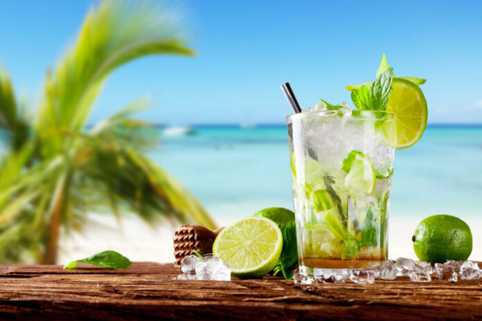 Mojito drink on wood with blur beach background