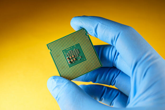 production of central processing units, gloved hand holds a cpu. Global chip shortage concept