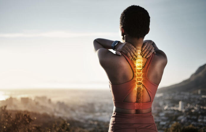 Spine injury, skeleton and back pain of fitness woman on mountains with sky background for sports exercise. Athlete, backache and red body bones for first aid emergency, joint pain and muscle anatomy
