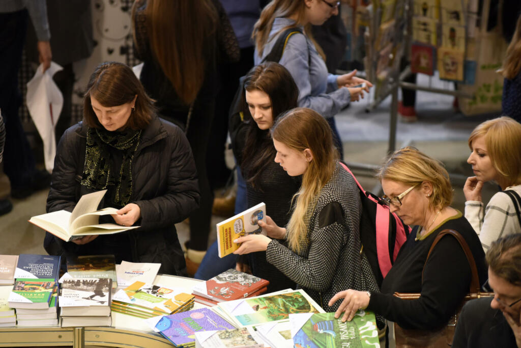 VILNIUS - FEBRUARY 26: Many people choose books at the indoor book market on February 26, 2016 in Vilnius, Lithuania. Vilnius is the capital of Lithuania and its largest city.