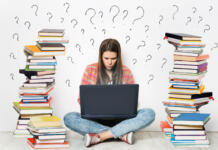 Ne pozabite na informativne dneve v Ljubljani in Mariboru Woman using Laptop. Student Girl working on Computer Search in Internet around Stacks of Books. Question Marks Drawn On White Wall Background. E Learning, Online Studying, Reading Books in Digital Library. Young Girl sitting on Floor next to heap of Books