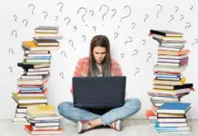 Ne pozabite na informativne dneve v Ljubljani in Mariboru Woman using Laptop. Student Girl working on Computer Search in Internet around Stacks of Books. Question Marks Drawn On White Wall Background. E Learning, Online Studying, Reading Books in Digital Library. Young Girl sitting on Floor next to heap of Books