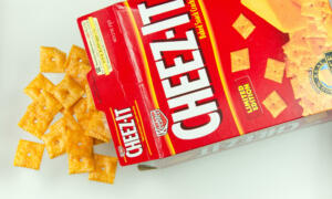 Bruce, Alberta, Canada- September 7, 2011: A box of the popular bite sized cheese cracker, Cheeze-Its, laying upon it\'s side with the crackers spilling from the box. This cracker is sold in most convenience and grocery stores in the United States and is sold internationally. It is manufactured by the Kellogg Company. This is a studio shot and the image is isolated on a white background.
