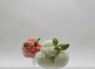 Recept za najboljši sladoled z okusom limone in bazilike Dva kozarca sladoleda, v enem je limonin sladoled, v drugem pa jagodni, poleg so jagode