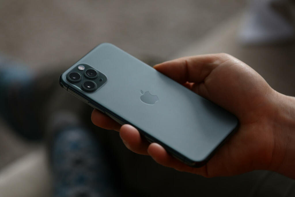 Minsk, Belarus - December 11, 2019: A man holds a new model apple iphone backside up closeup . Illustrative editorial