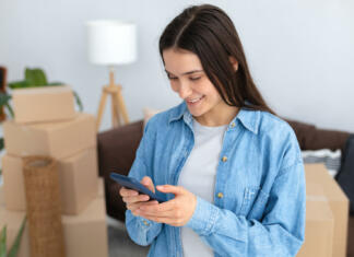 Študentom, prizadetim v poplavah, dodatnih 100 točk za subvencionirano bivanje Moving to a new house, rental housing. Happy young caucasian woman using a mobile phone to search and order a transportation service and movers to move to a new home