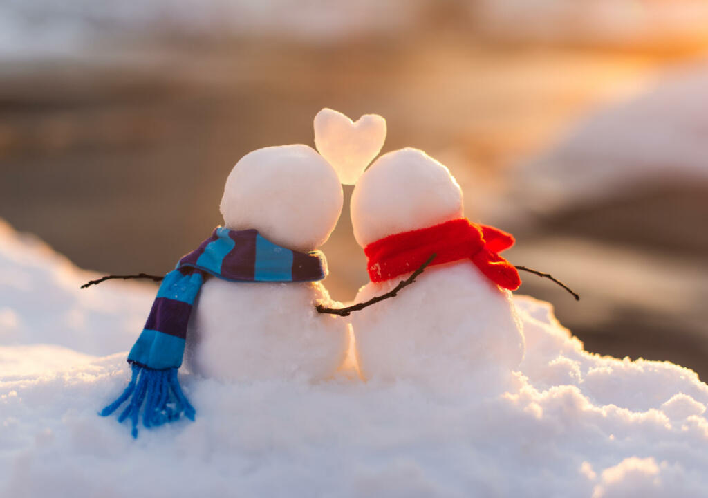 Cute snowman couple in love with snow heart between them. in Kingston, Ontario, Canada