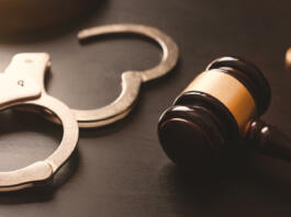 Handcuffs and wooden gavel. Crime and violence concept.