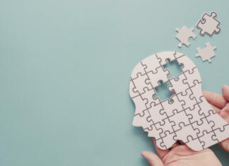 Kaj je kratkoročni spomin? Hands holding brain with puzzle paper cutout, autism, Epilepsy and alzheimer awareness, seizure disorder, world mental health day concept