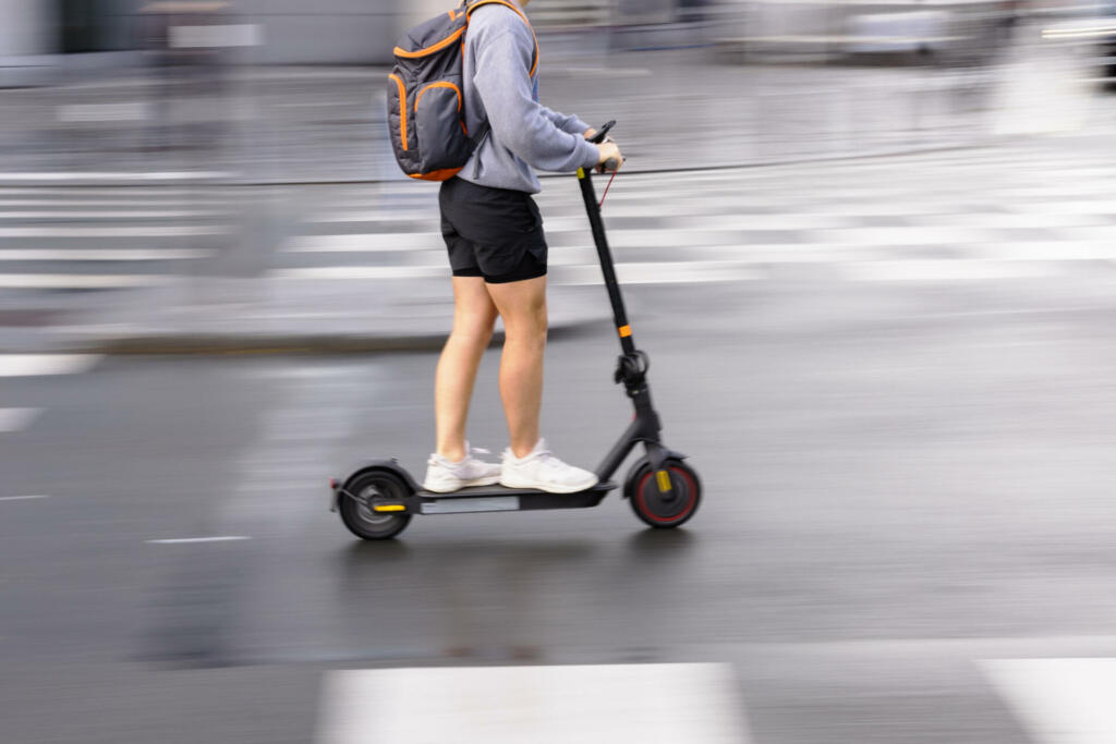 motion blur picture of an unrecognizable person with an electric scooter on a city street