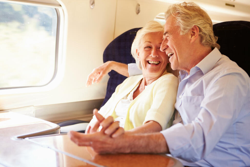 Senior Couple Relaxing & cuddling On Train Journey