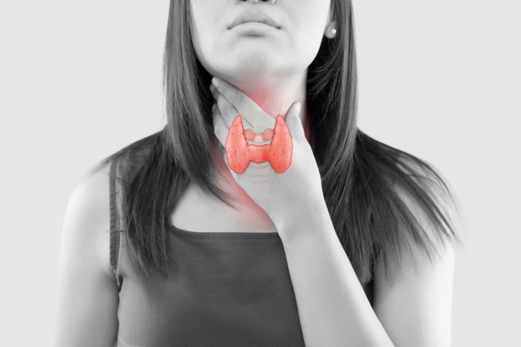 The illustration of the thyroid is on the woman throat, Human thyroid gland control. Sore throat of a people against a gray background. The concept of healthcare and medicine.
