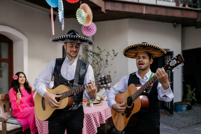 Two men playing guitar while singing