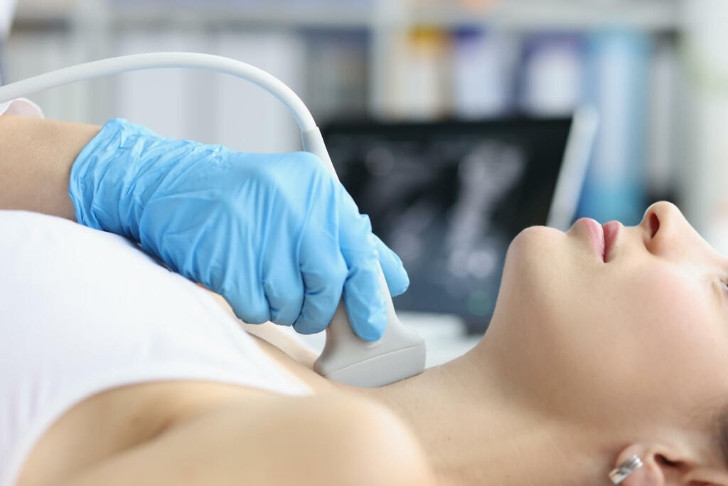 Woman receives ultrasound of thyroid gland from doctor. Thyroid hormones and thyroid gland