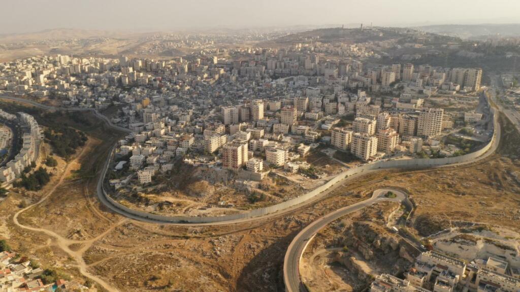 Aerial view of Left side Anata Palestinian town and Israeli neighbourhood Pisgat zeev