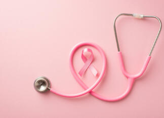 Roza oktober: Opomnik tega, kaj lahko storiš zase! Breast cancer awareness concept. Top view photo of pink silk ribbon and stethoscope on isolated pastel pink background