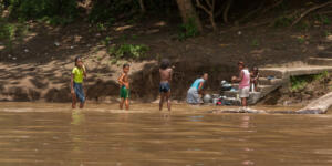 Darien Province, Panama. 07-18-2019. An indigenous boys from the Darien Province, in Panama, Central America, are playing on the river while women are washing cloths. i