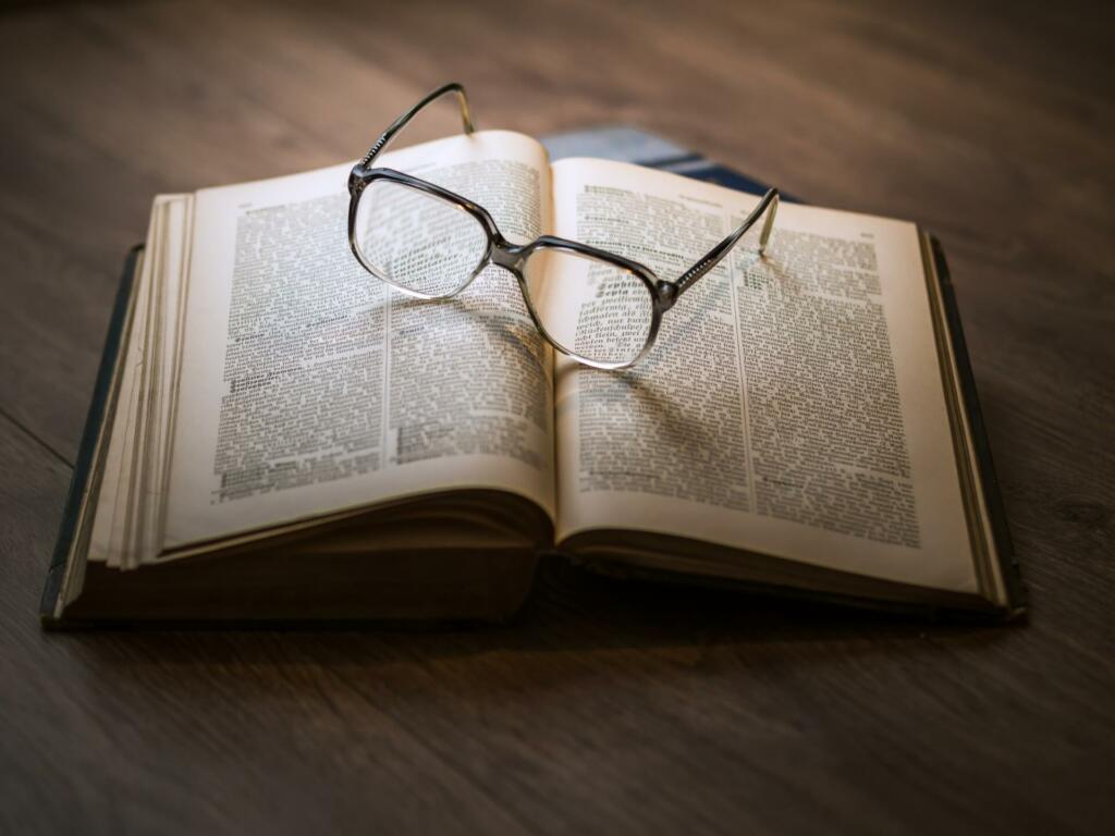 odprta knjiga in na njej očala