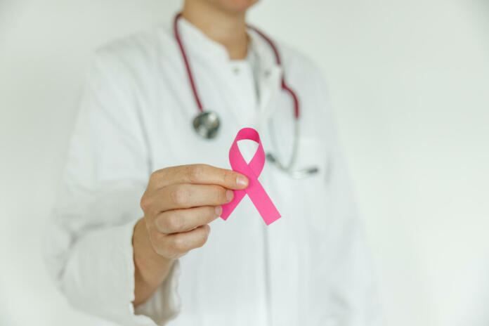 Doctor woman with pink ribbon, supporting symbol of breast cancer awareness