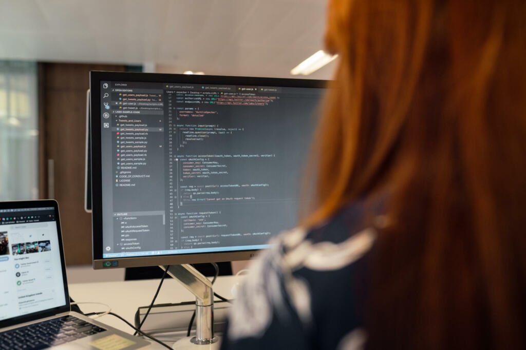 Female software engineer coding on computer